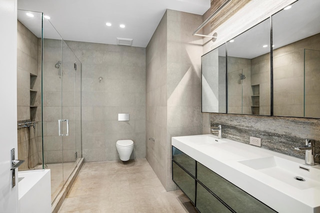 88 Lexington Ave Unit 507, New York City, NY 10016 - bathroom with tile walls, a shower stall, double vanity, tile patterned flooring, and recessed lighting