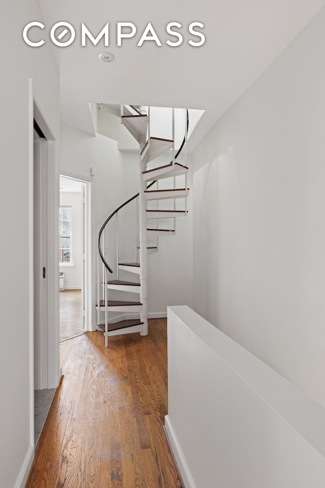 interior space with stairs, wood finished floors, and baseboards