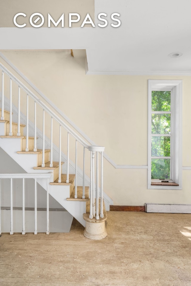 stairs featuring ornamental molding and wood finished floors