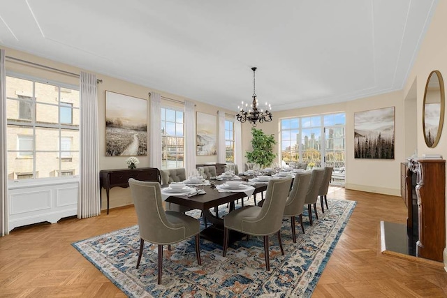 dining room with light parquet flooring, a healthy amount of sunlight, and an inviting chandelier