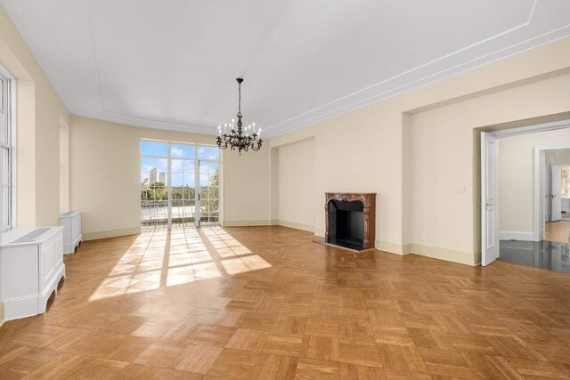 unfurnished living room featuring ornamental molding, a chandelier, and wood-type flooring