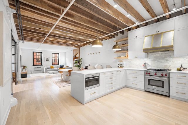 kitchen with decorative light fixtures, designer stove, light countertops, open floor plan, and white cabinetry