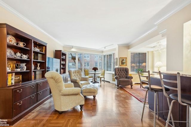 living area featuring dark parquet flooring, ornamental molding, and track lighting