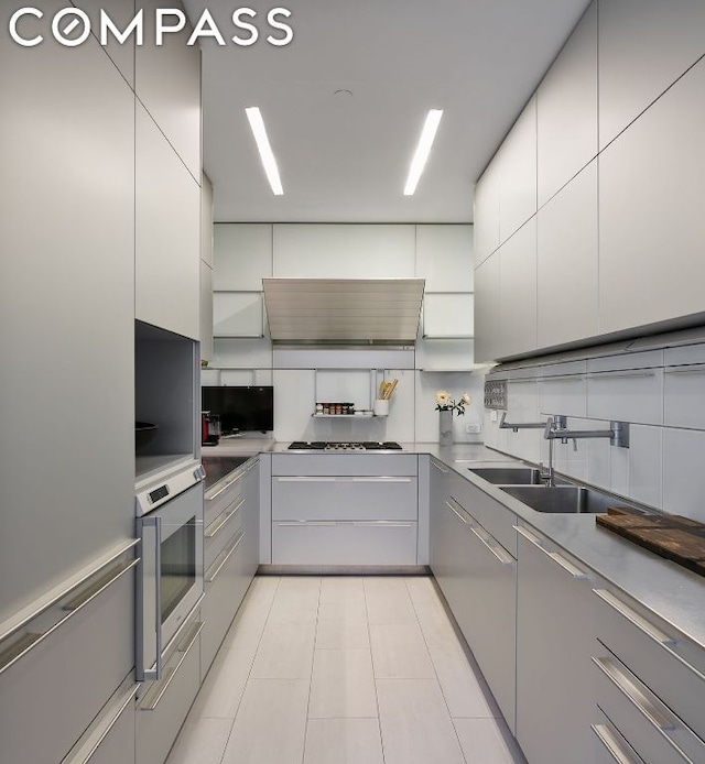 kitchen featuring extractor fan, light tile patterned floors, stainless steel appliances, and sink