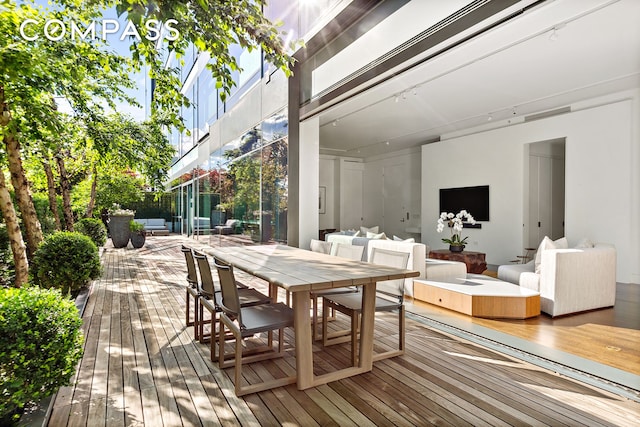 wooden terrace with an outdoor living space and outdoor dining area