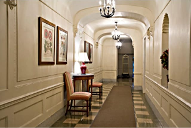 12 E 97th St Unit 8E, New York City, NY 10029 - hallway with a decorative wall, a chandelier, and arched walkways