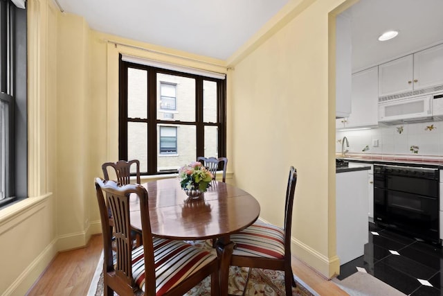 dining space featuring light wood-style floors, recessed lighting, and baseboards