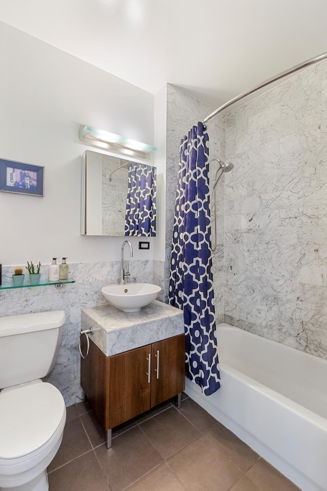 full bath with tile walls, shower / bath combination with curtain, toilet, vanity, and tile patterned floors