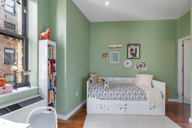 bedroom with baseboards and wood finished floors