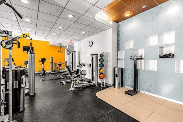 gym featuring recessed lighting, a paneled ceiling, and baseboards