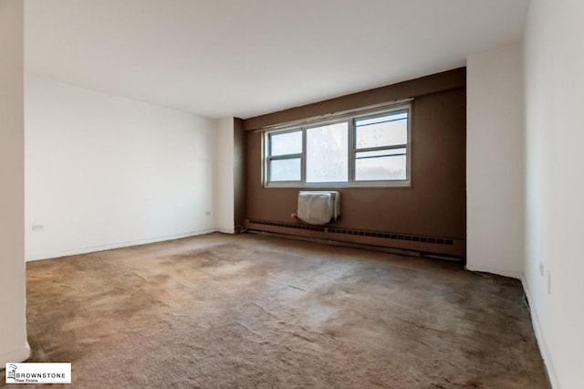 carpeted spare room featuring a baseboard heating unit