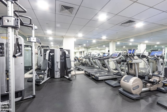 gym with a paneled ceiling and visible vents