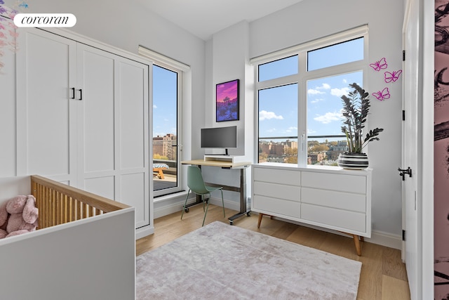 bedroom featuring light wood finished floors, visible vents, and baseboards