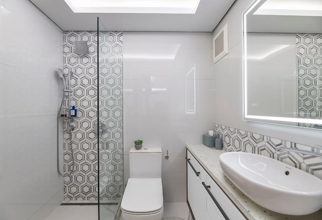 bathroom featuring vanity, tiled shower, tile walls, and toilet