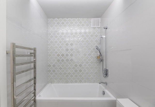 bathroom featuring toilet, visible vents, tub / shower combination, and radiator heating unit