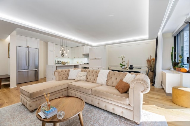 living room featuring a notable chandelier and light hardwood / wood-style flooring