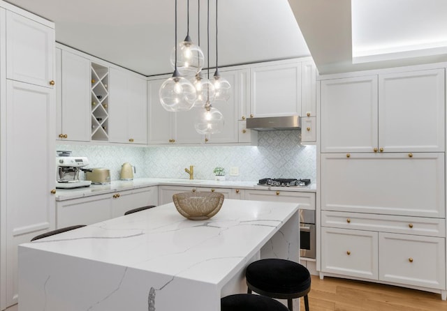 kitchen featuring white cabinetry, light wood-type flooring, and pendant lighting