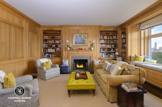 living room featuring built in features, a warm lit fireplace, and crown molding