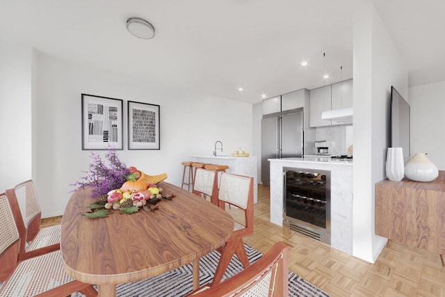 dining room featuring beverage cooler and light parquet floors