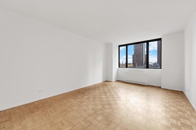 empty room featuring radiator and light parquet flooring