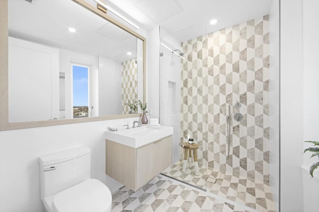 bathroom featuring vanity, tiled shower, and toilet