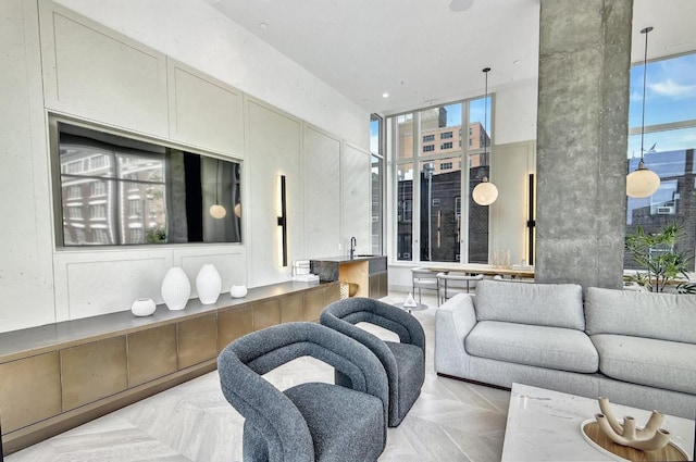 living room featuring light parquet flooring, sink, and a towering ceiling