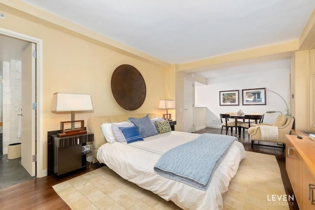 bedroom with hardwood / wood-style flooring and ensuite bathroom