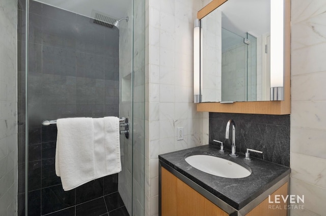 bathroom with tasteful backsplash, vanity, and walk in shower