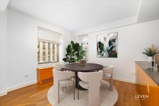 dining area featuring light wood-style floors and baseboards