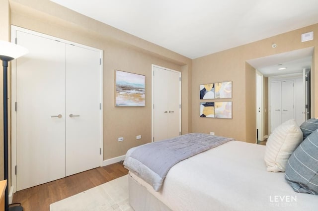 bedroom featuring baseboards, visible vents, and wood finished floors