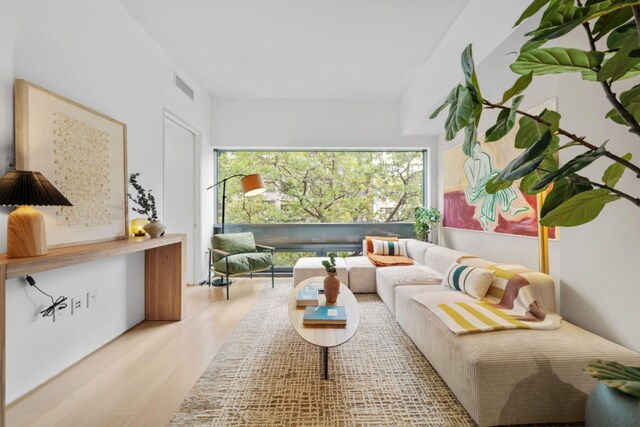 bedroom with light wood-type flooring and connected bathroom