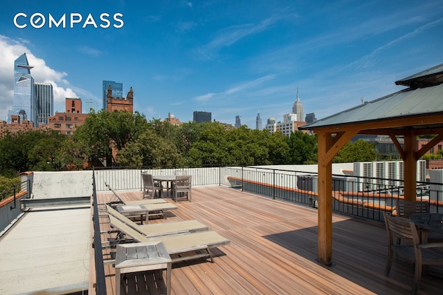 deck featuring a city view and outdoor dining area