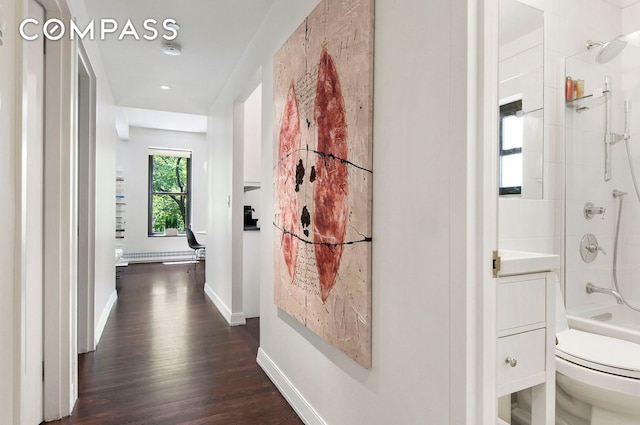 hall featuring baseboards and dark wood-style flooring