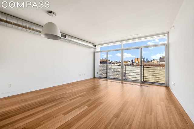 spare room with hardwood / wood-style flooring and floor to ceiling windows