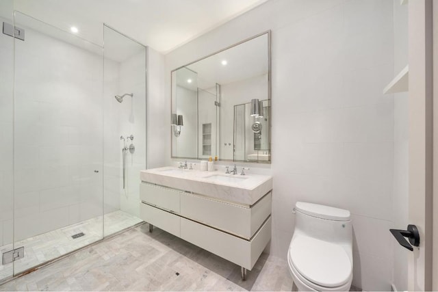 bathroom with a sink, double vanity, a shower stall, and toilet