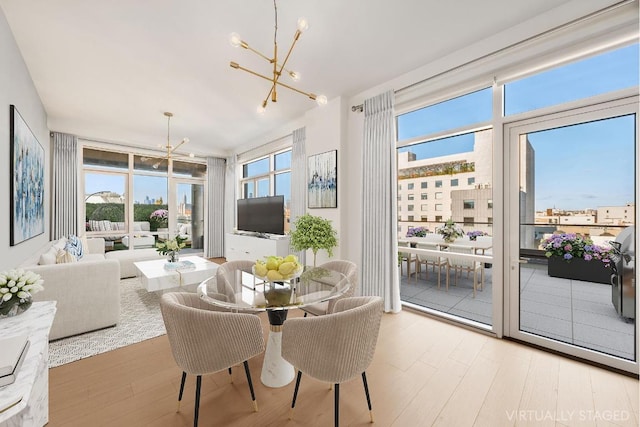 dining space featuring light wood-style flooring and a chandelier