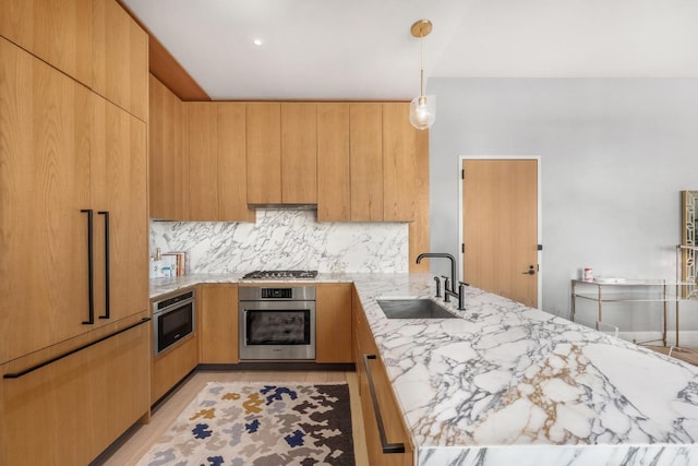 kitchen featuring light brown cabinets, modern cabinets, appliances with stainless steel finishes, and a sink