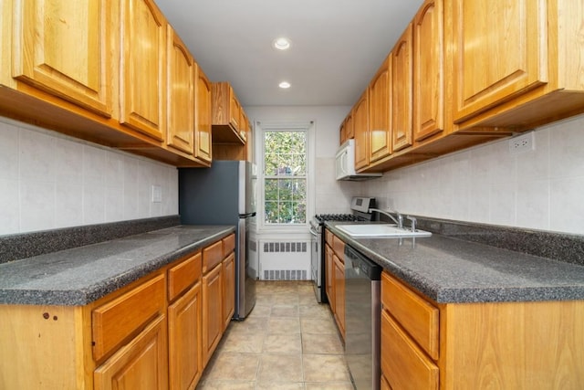 kitchen featuring appliances with stainless steel finishes, sink, light tile patterned floors, and backsplash