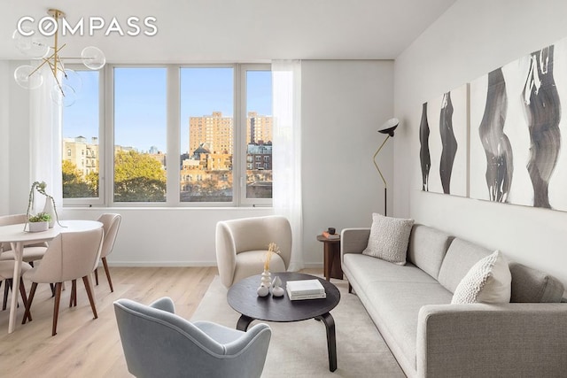 living area with a view of city, baseboards, and light wood-type flooring