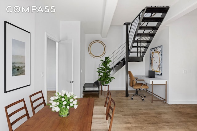 office space featuring beam ceiling, baseboards, and wood finished floors