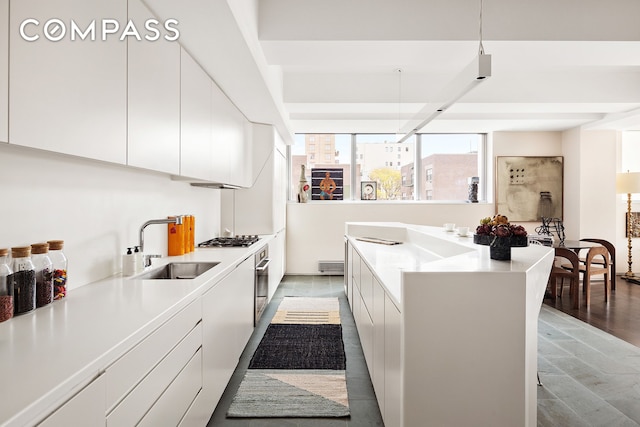 kitchen featuring modern cabinets, white cabinets, a sink, and light countertops