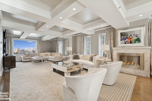 living area with beamed ceiling, coffered ceiling, a high end fireplace, and crown molding