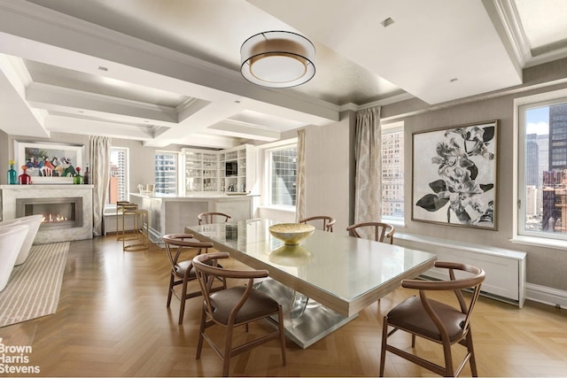 dining space featuring baseboards, coffered ceiling, ornamental molding, beamed ceiling, and a high end fireplace