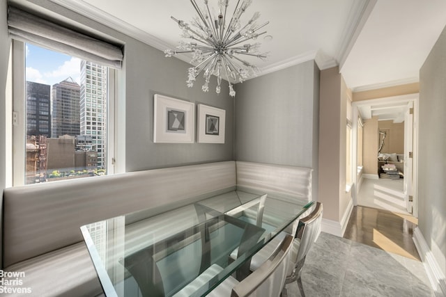 dining area with a view of city, ornamental molding, baseboards, and a notable chandelier