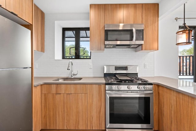 kitchen featuring sink, decorative backsplash, hanging light fixtures, and appliances with stainless steel finishes