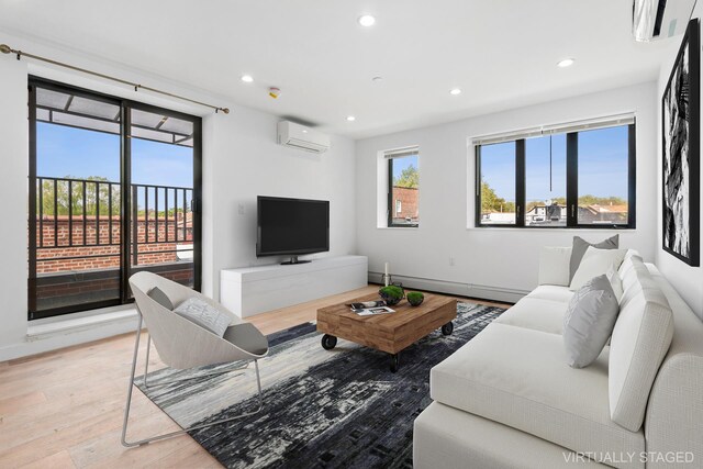 living room featuring wood-type flooring, an AC wall unit, and baseboard heating