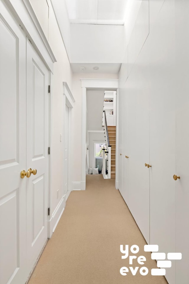 hallway with light colored carpet and stairway