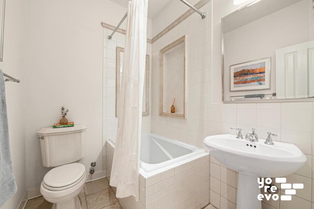 full bath with tiled shower / bath, tasteful backsplash, toilet, tile patterned flooring, and baseboards