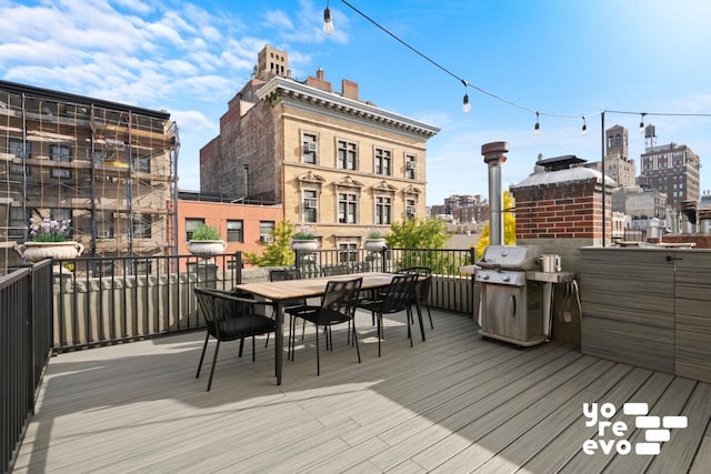 wooden terrace featuring outdoor dining space, a grill, and a view of city