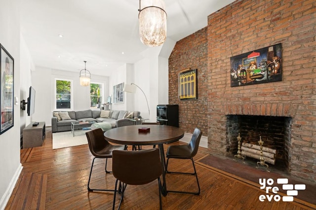 dining area with a brick fireplace, baseboards, and dark wood-style floors